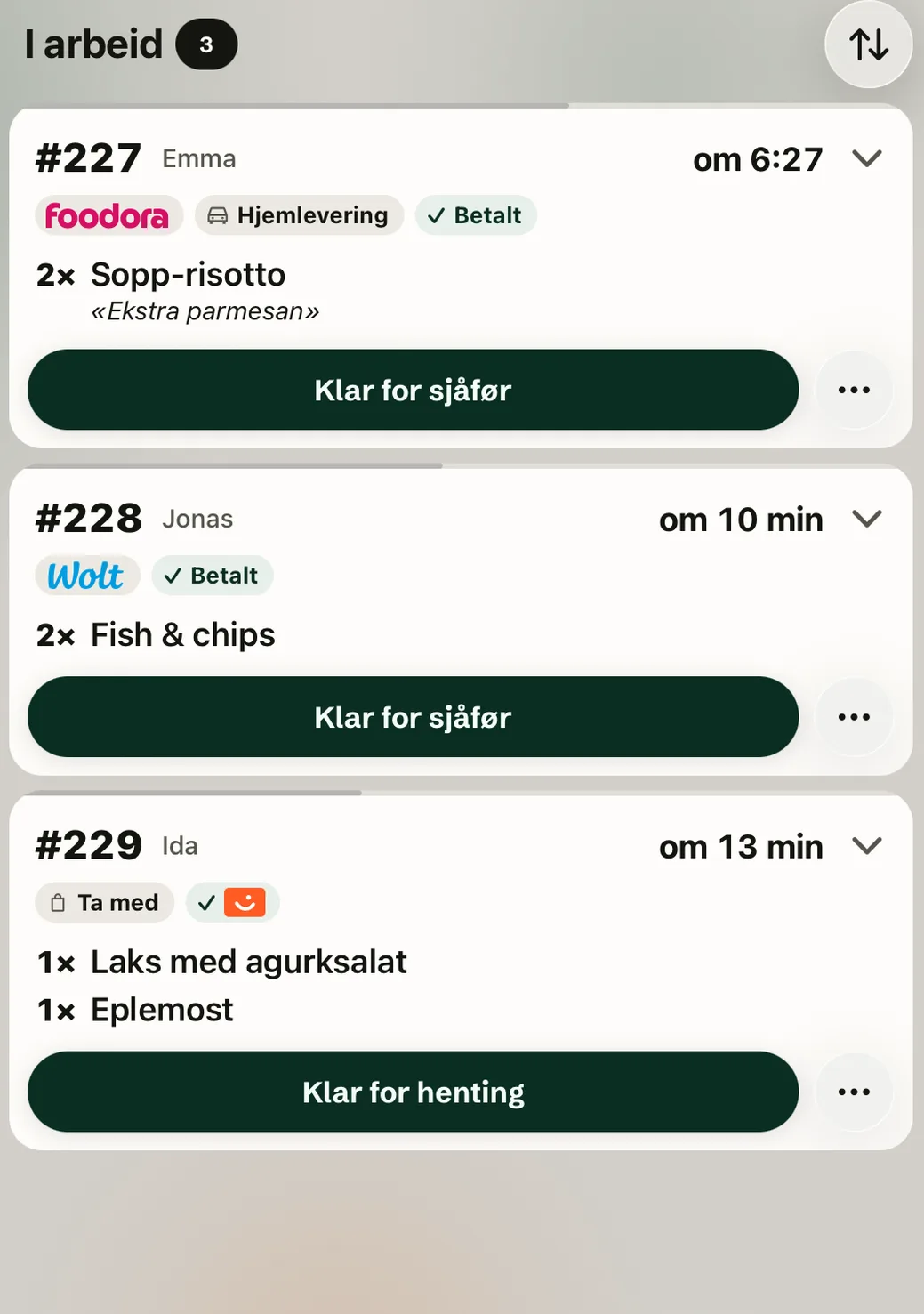 The In progress column on the kitchen screen on iPad in light mode: Foodora delivery 227, Wolt order 228 and order 229 from the app.