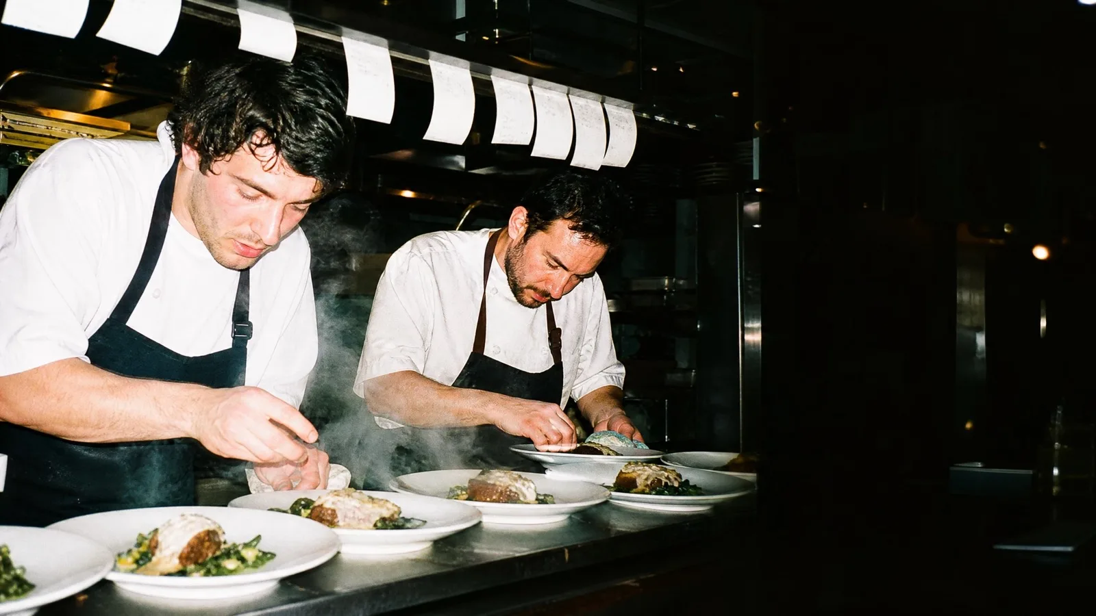 Two cooks plate up at the pass.
